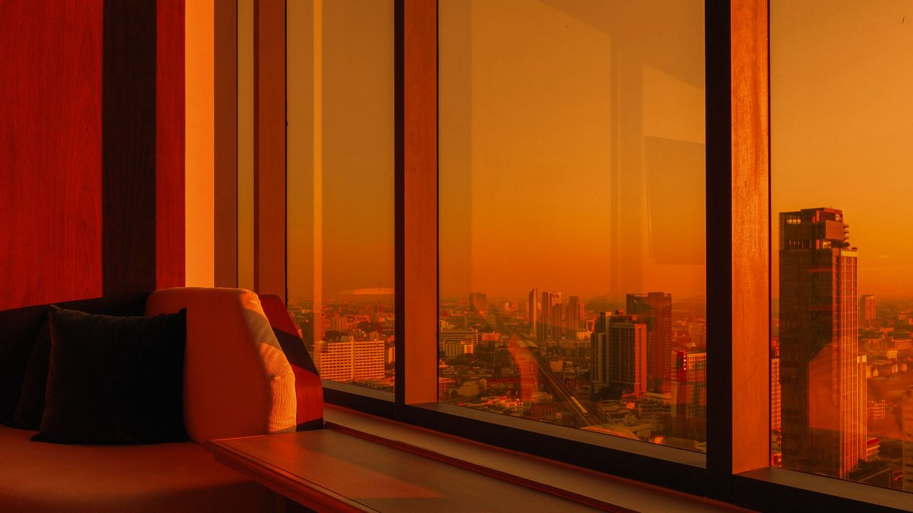 Skyline de la ciudad al atardecer visto desde ventanales de oficina