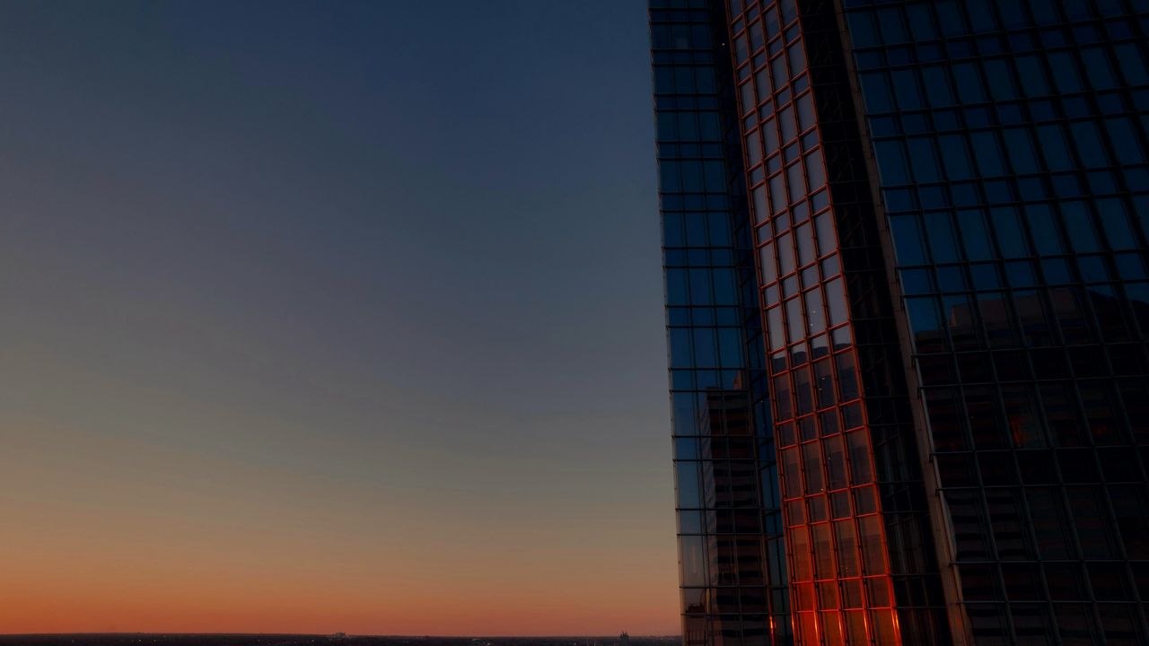 Fachada de vidro geométrica refletindo o céu